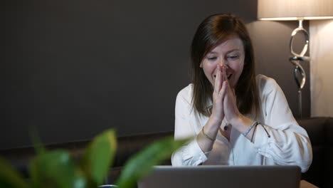 a successful professional woman working on a computer winning and celebrating