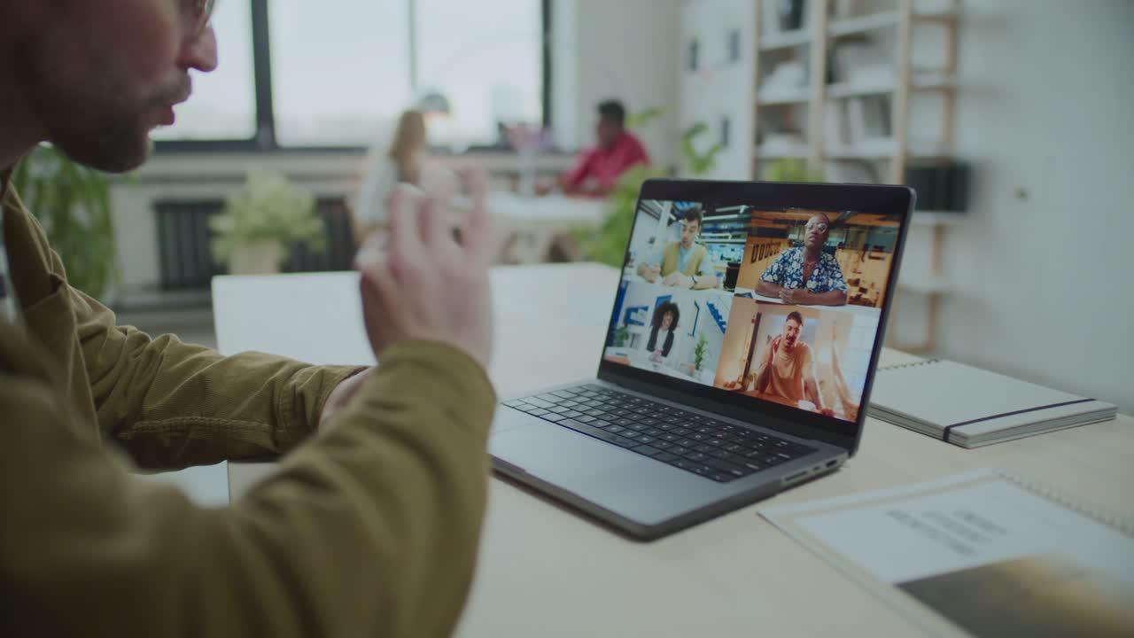 Uomo in videoconferenza con il team aziendale alla scrivania in ufficio