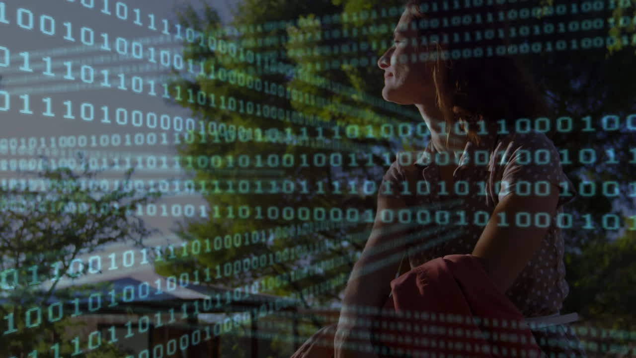 woman holding red jacket sitting on campus lawn, showing digital technology binary code overlay