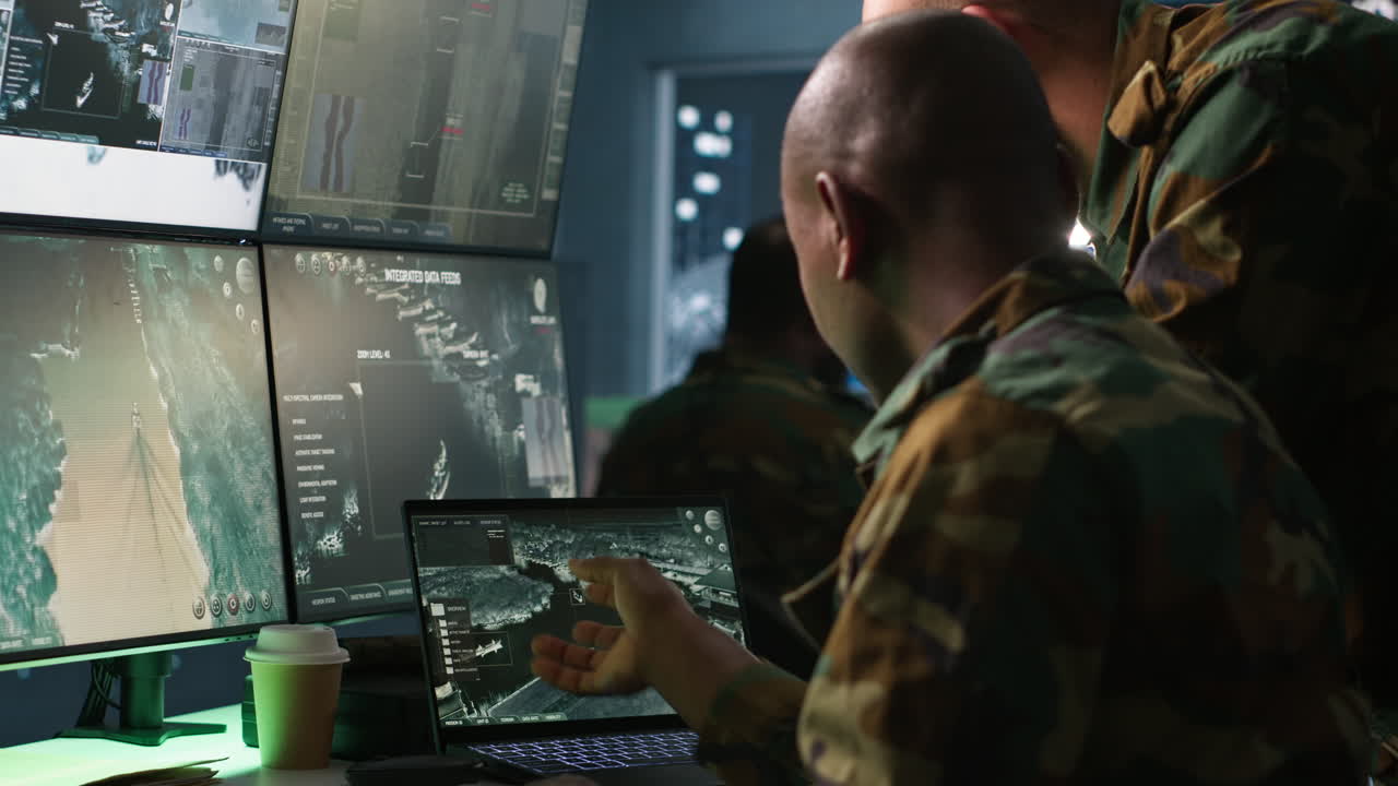 Team of army specialists examining data in monitoring room