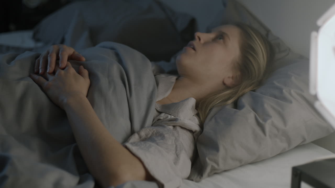 밤에 침대에서 자고 있는 여자