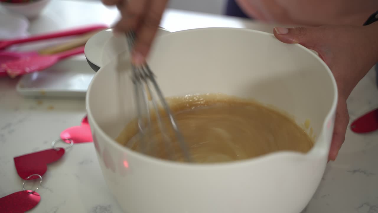 Whisking a bowl of batter into white bowl making a special valentine's day cake vegan chocolate cake eggless plant based dairy free