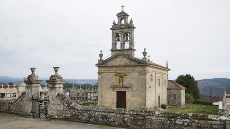 Pan-across-gated-entrance-with-moss-covered-wall-of-Santa-Maria-de-Freas-in-Punxin-Ourense-Galicia-Spain