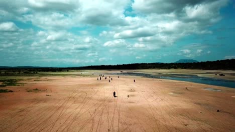 Aerial-Follow-Of-Riders-In-Motorcycles-Traveling-Around-Lake-Magadi-In-Kenya,-East-Africa