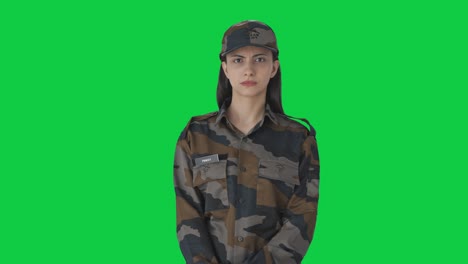 una mujer indígena enojada, oficial del ejército, mirando la pantalla verde de la cámara.
