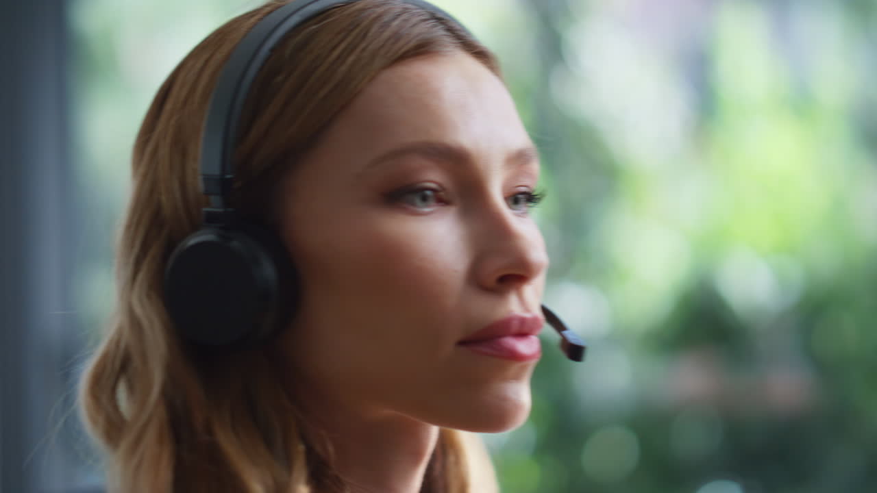 Nærbilde av kvinnelig operatør som snakker i headset og gir teknisk støtte på et kontor