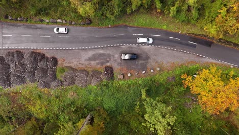 car traffic passing through forest road, aerial drone top-down view nature