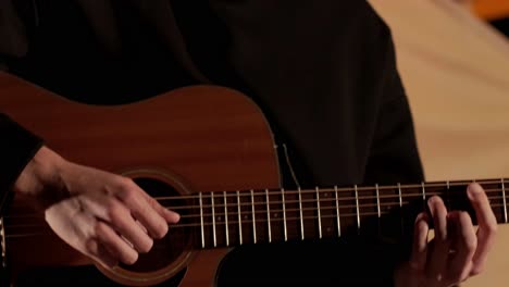 man plays the guitar and sings songs in a tent with light bulbs