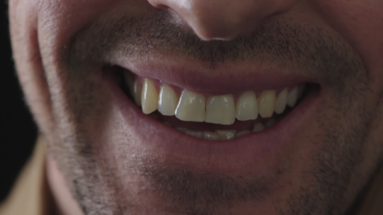 cerca de la boca masculina sonriendo dientes felices con pelo facial sin afeitar rastrojo