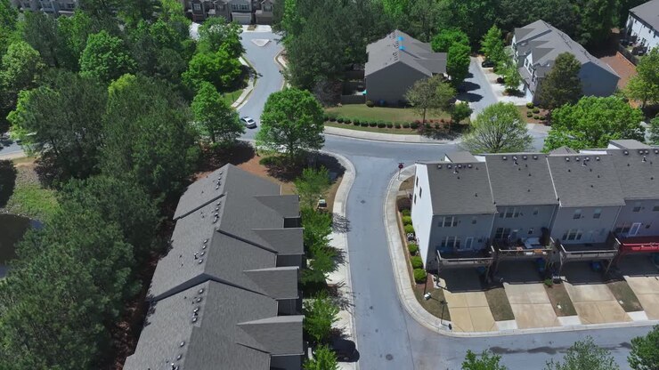 Grå rækkehuse og lejligheder i en forstad til byen. Solskinsdag i Atlanta, Georgia. Nybyggede boligblokke i USA. Luftfoto ovenfra. Bil på gaden.