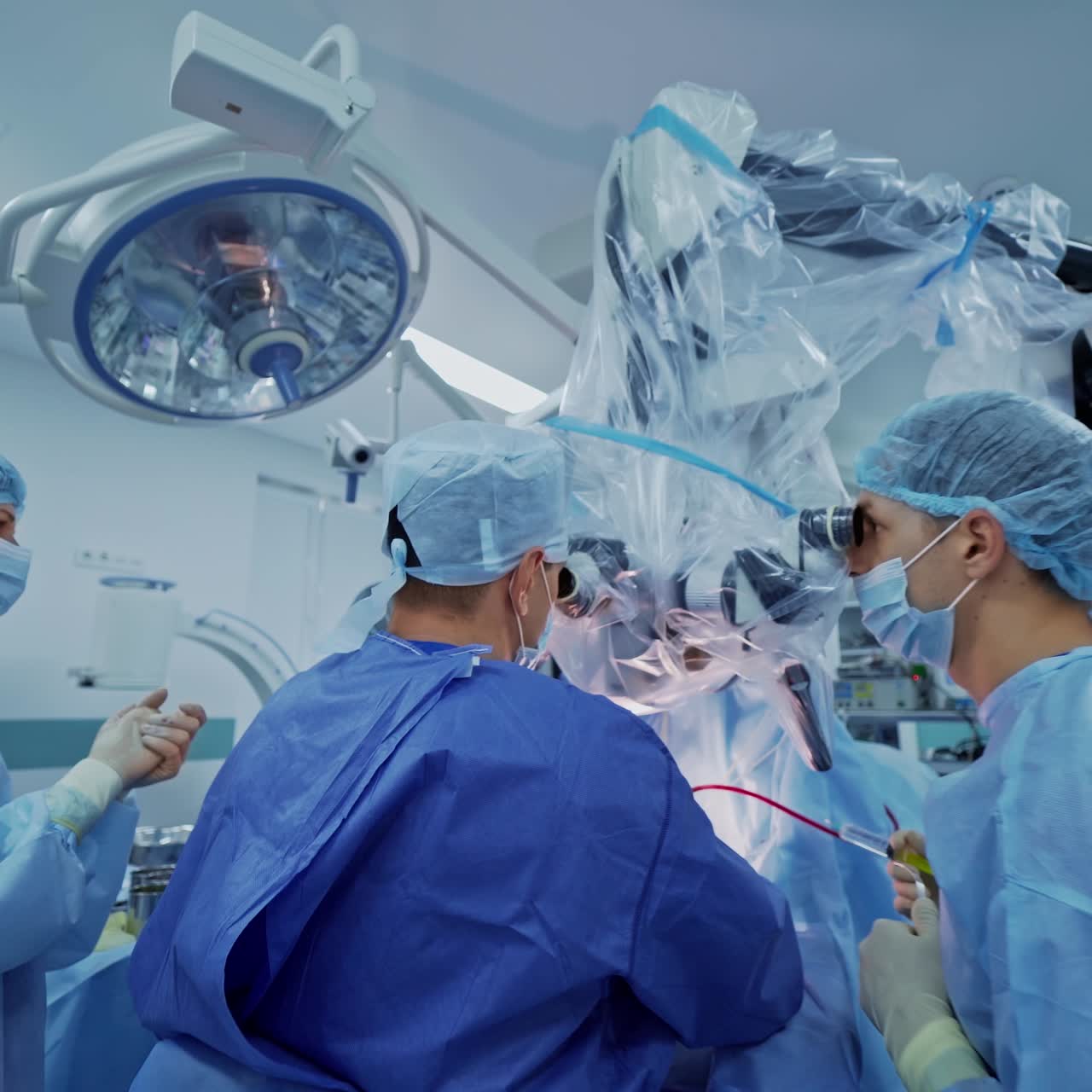 Modern microscope in surgical room. Group of doctors conduct a neurosurgery with a new equipment in the hospital. New technologies in medicine.