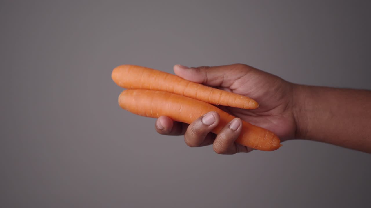 Two Carrots Held in Hand