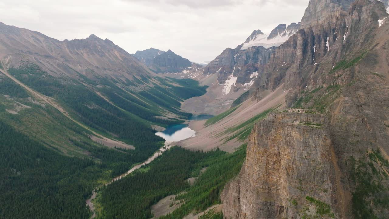 órbita aérea sobre la cordillera de las montañas rocosas canadienses, el bosque de pinos verdes y el lago en el parque nacional de banff, alberta, canadá
