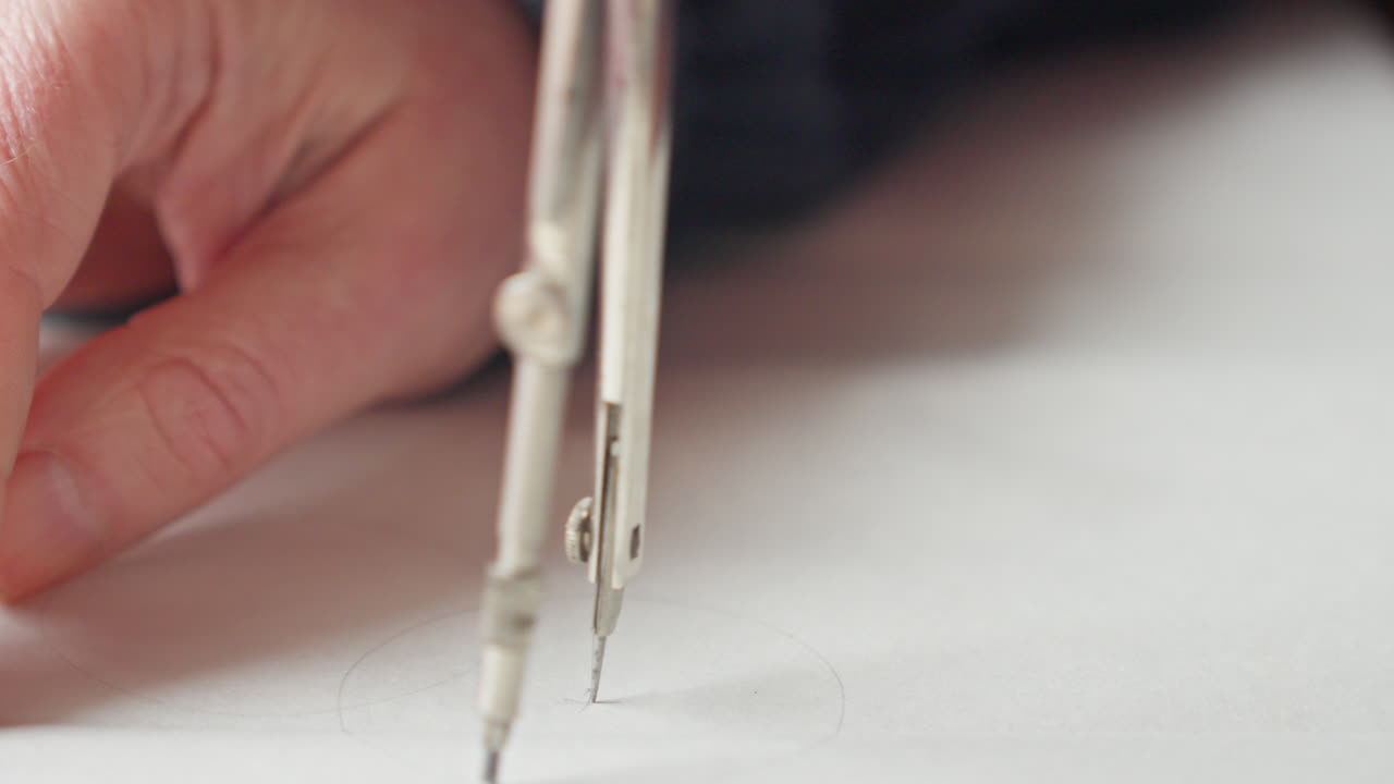 Vista macro di un compasso che disegna un cerchio perfetto, evidenziando precisione, controllo e la bellezza della precisione geometrica