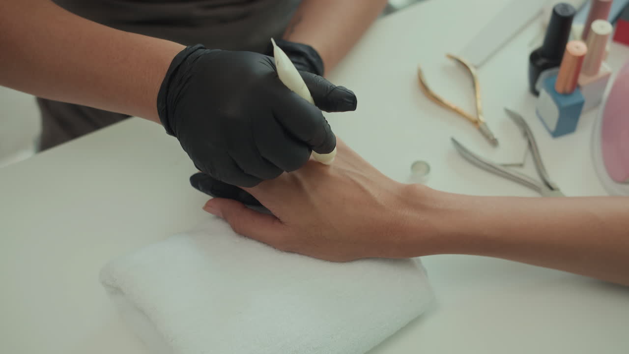 Anonymous Beautician Applying Nourishing Cream on Hands of Client at Salon