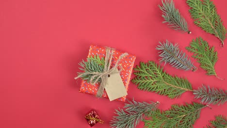 fondo de navidad rotación de 360 grados. ramas de abeto y caja de regalos girando en fondo rojo.