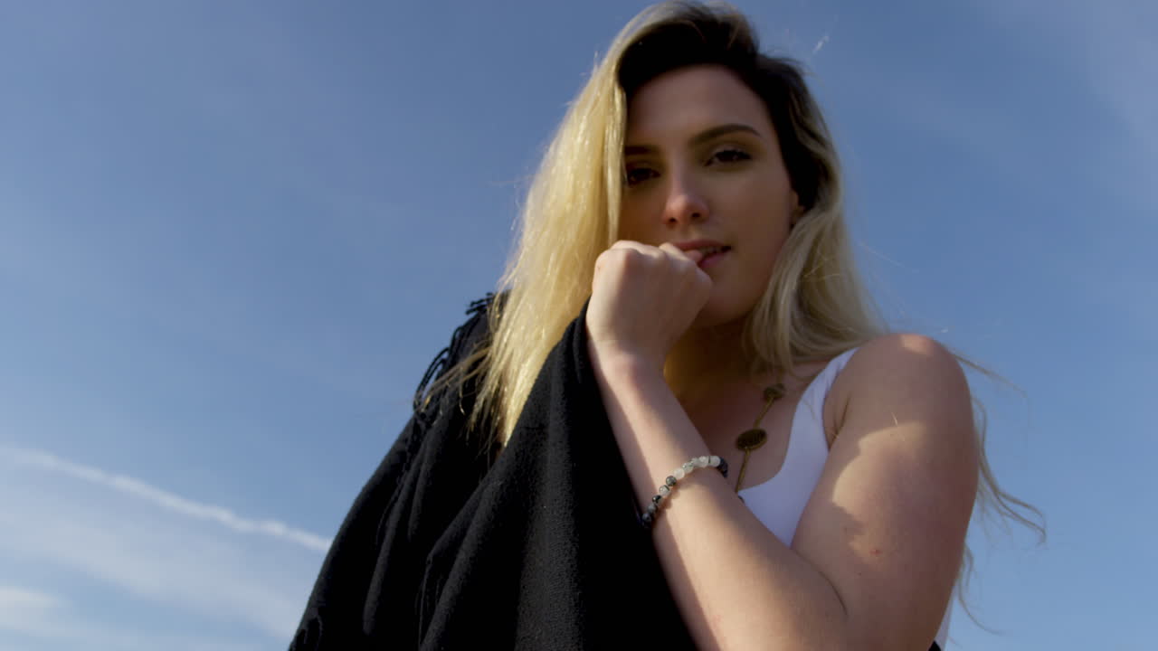 симпатичная молодая блондинка позирует и уверенно улыбается