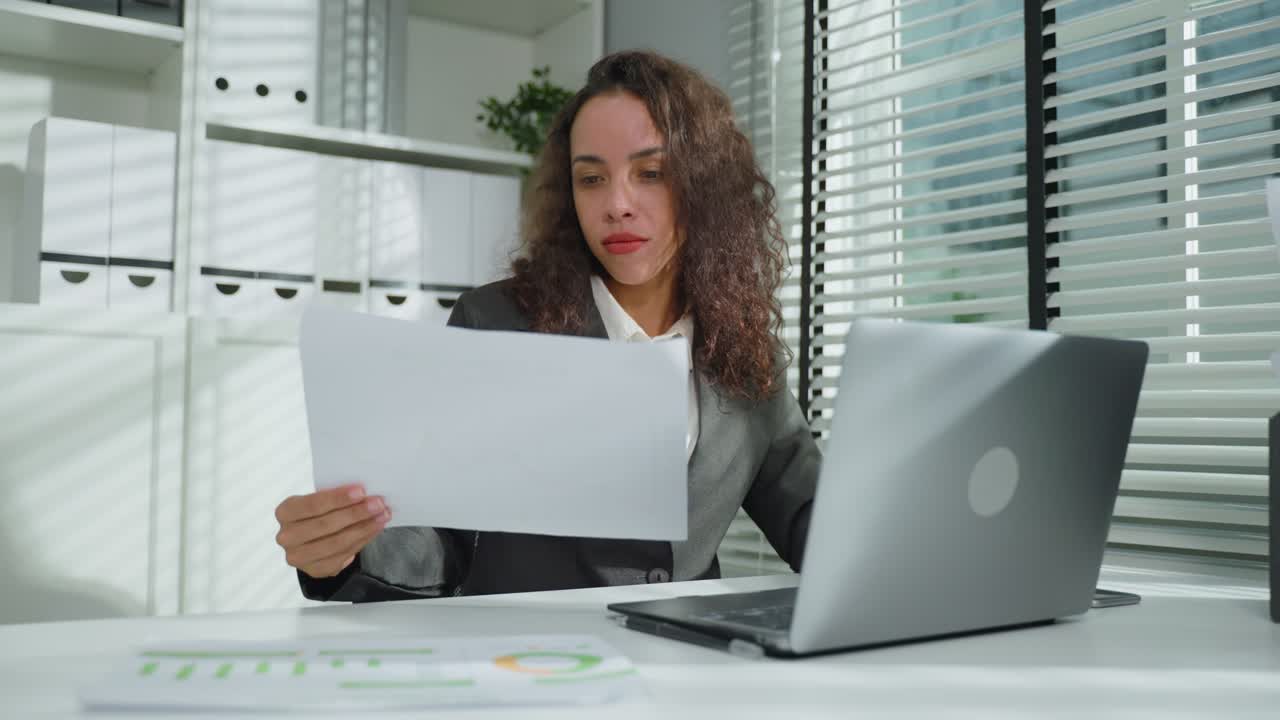 mujer de negocios revisando documentos en una oficina moderna