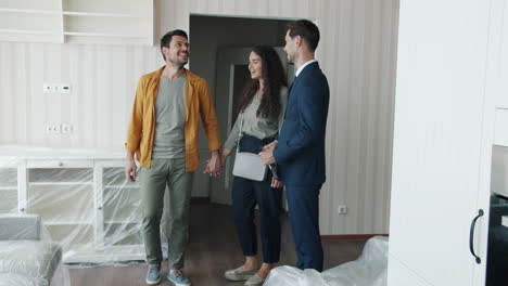 couple touring a new apartment with a real estate agent.
