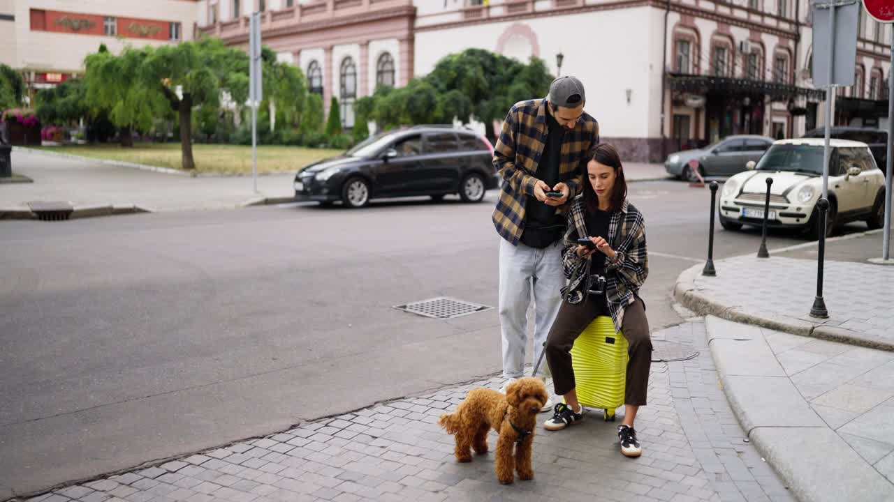 una pareja con su perro caminando por una calle de la ciudad.