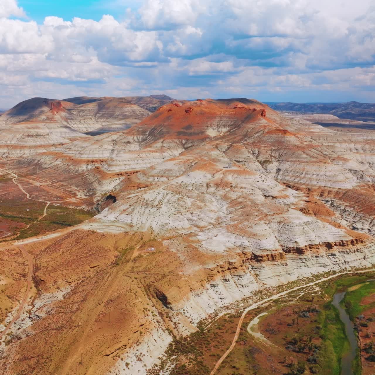 Beautiful bare mountains on cloudy daytime. Railroad and narrow river going around the rocks. Wyoming State, USA