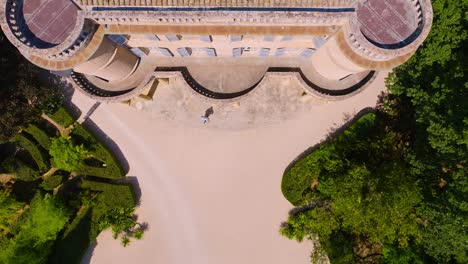 Captured-from-above,-the-scene-reveals-a-stone-castle-surrounded-by-a-lush-green-garden