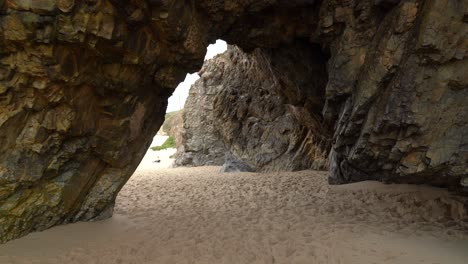 cueva hueca en gruta da adraga en una playa de arena