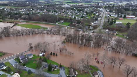 flooded trees and roads near a suburban neighborhood, severe weather impact