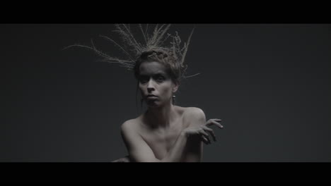 a woman dressed as mother nature moves slowly in a dance-like motion