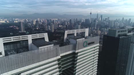 aerial view of q sentral tower roofdeck in kuala lumpur, malaysia with distant view of menara kuala lumpur - stunning cityscape - aerial shot