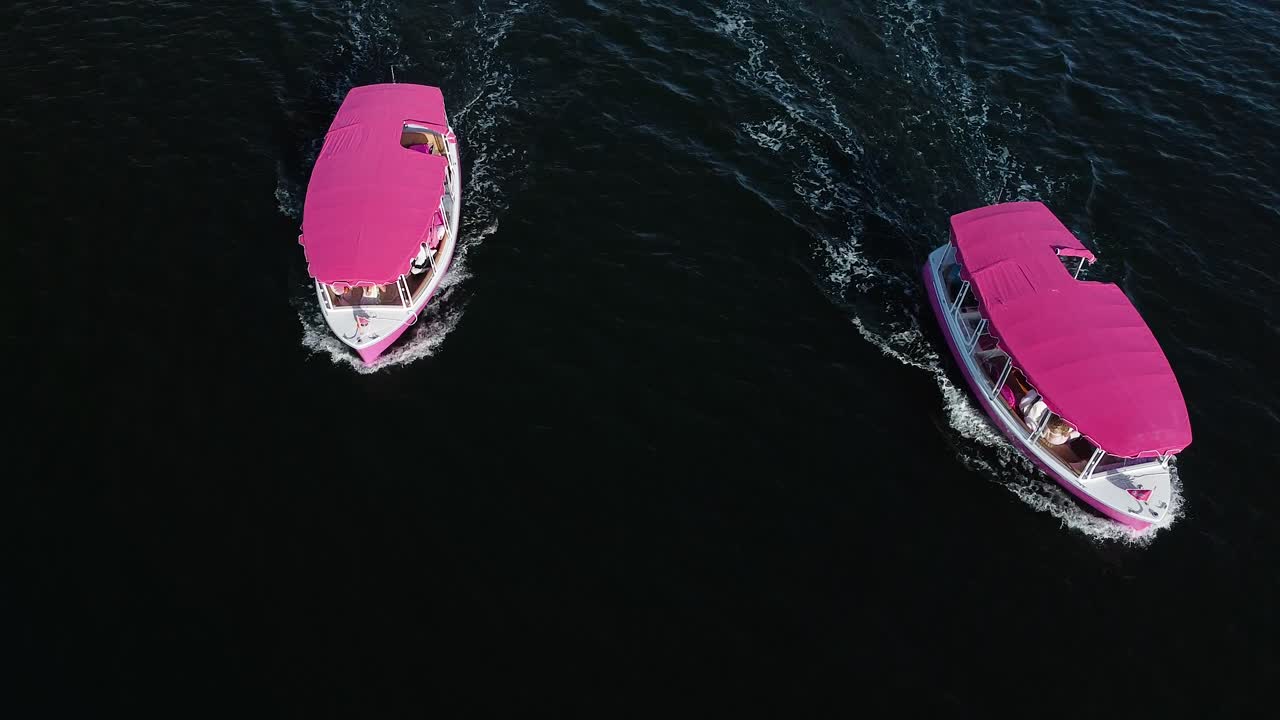 воздушный вид двух розовых лодок, движущихся рядом друг с другом в океане