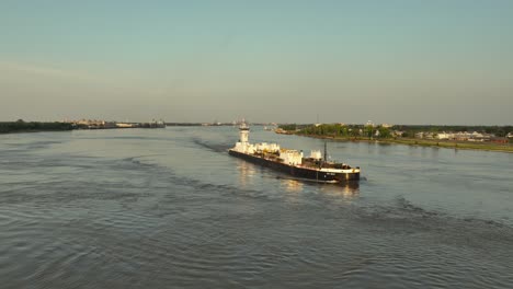 barge and pushboat heading down the mississippi river near new orleans