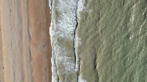 Toma-De-Drones-De-Hastings,-Reino-Unido,-Toma-De-Arriba-Hacia-Abajo-Volando-Sobre-La-Playa-De-Hastings,-Olas-Rompiendo-En-La-Playa-Bordeada-De-Arena