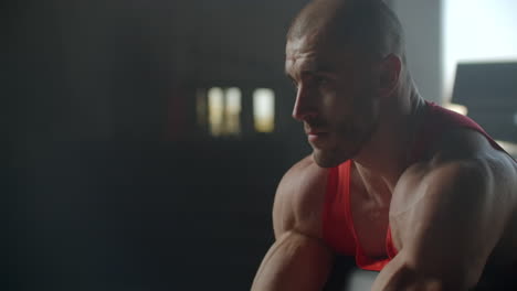 entrenamiento de fuerza brazo bíceps con barra. hombre delgado fuerte con grandes músculos levanta una barra sentado en el gimnasio en un banco.