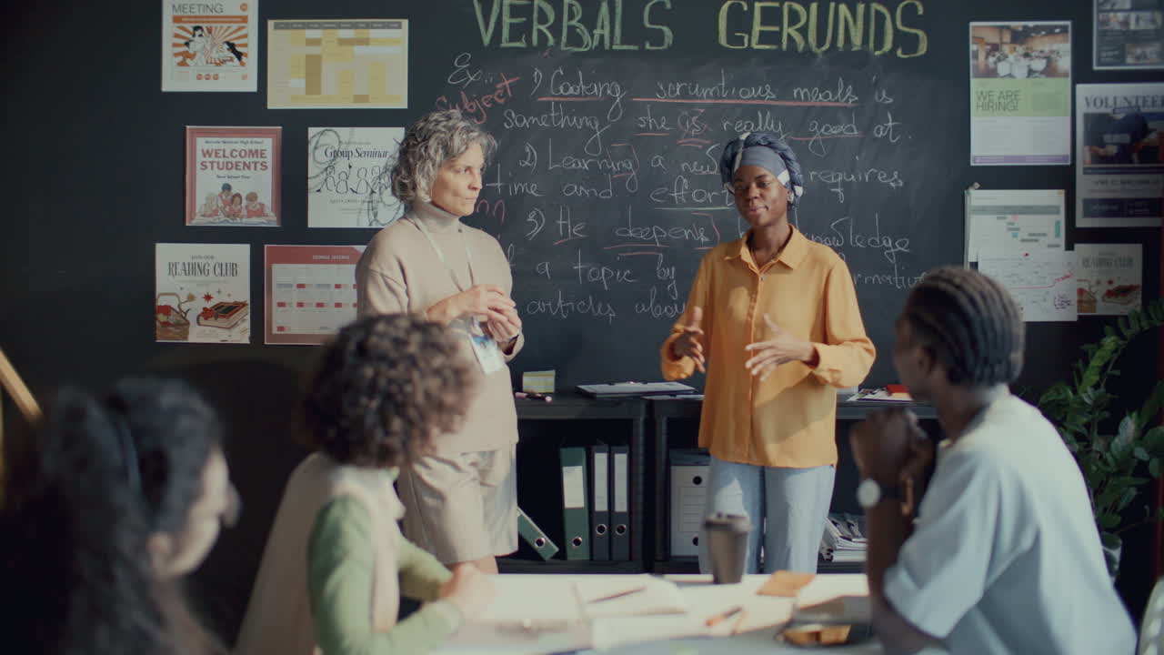 Afroamerikanisches Mädchen beantwortet Fragen an der Tafel während des Englischunterrichts