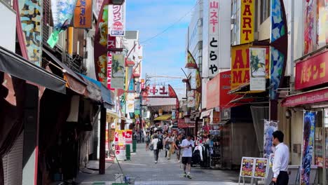 busy pedestrian street in japan with colorful signs and shops on a sunny day