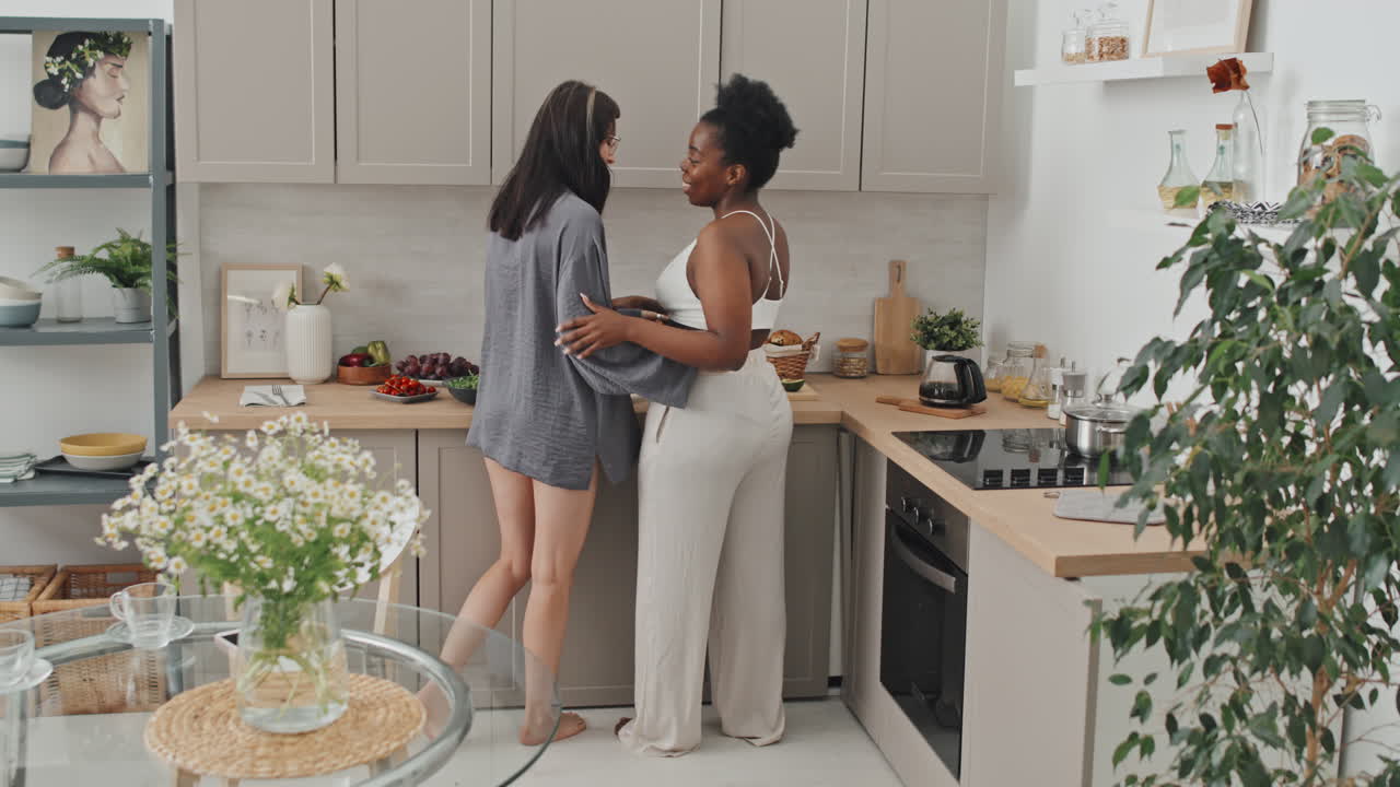 Coppia lesbica felice che si abbraccia in cucina