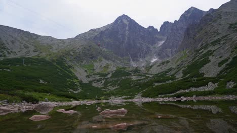 view over skalnate pleso of cable car traveling up to imposing lomnica peak