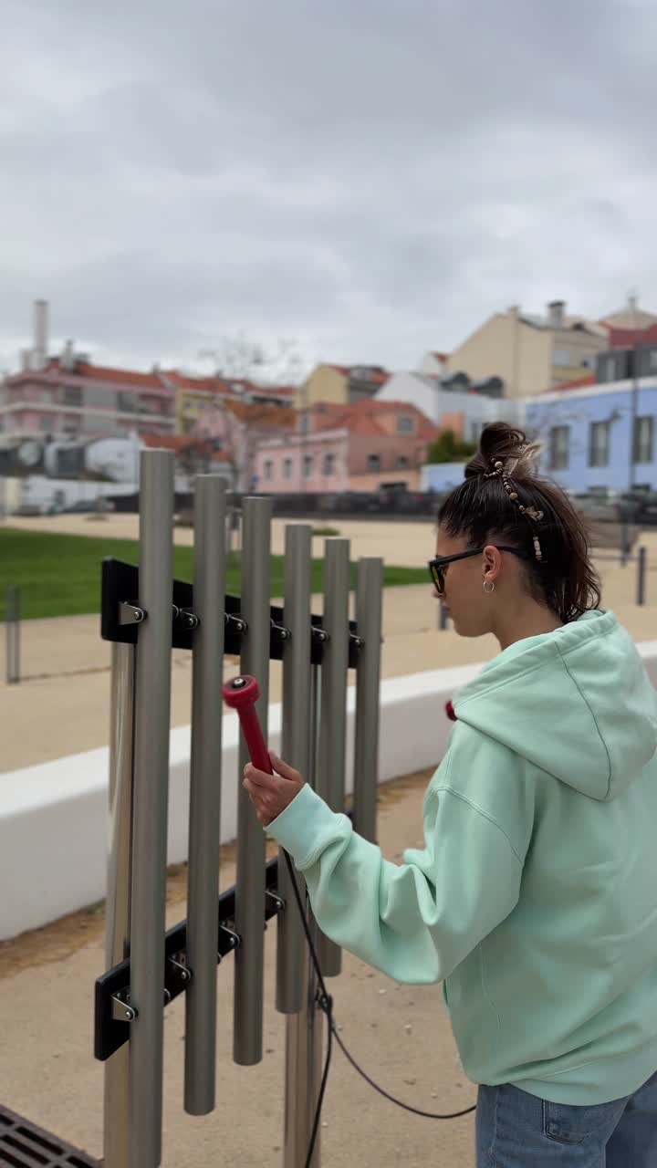 Woman playing tubular bells in a park