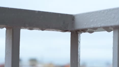gotas de lluvia en la barandilla del balcón cayendo mientras llueve