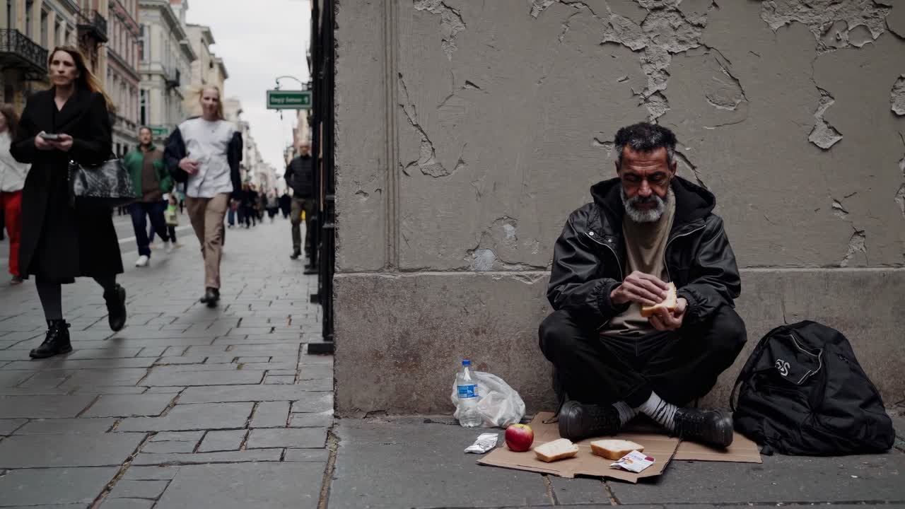 hombre sin hogar comiendo en la calle