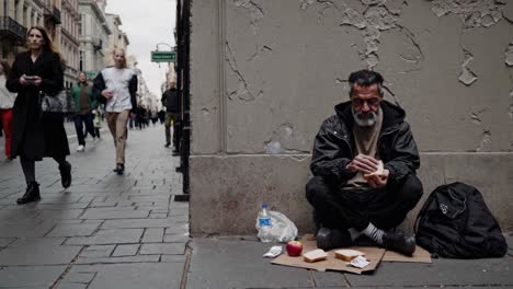 homeless man eating on the street