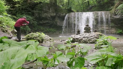 Fotógrafo-Que-Busca-Capturar-Una-Roca-En-Primer-Plano-Con-La-Cascada-Al-Fondo