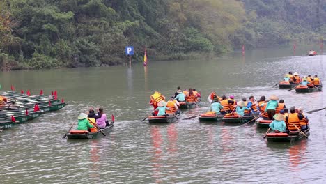 groups of tourists rowing boats on a scenic lake