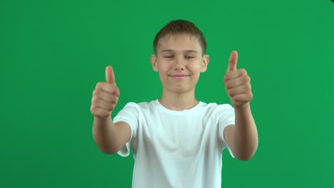 un adolescente alegre gestando los pulgares hacia arriba sobre la pantalla verde croma clave de fondo. como, acuerdo, concepto de aprobación