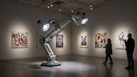 an innovative robotic arm showcases artistic expression in a modern gallery, enabling unique interactions between art and technology amidst striking visuals