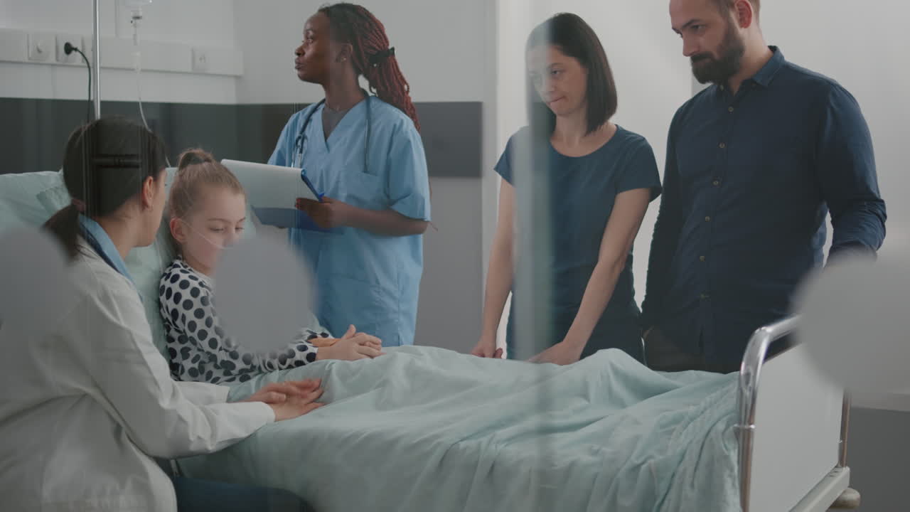 Pediatric doctor examining breathing sickness symptoms while african american nurse checking IV drip