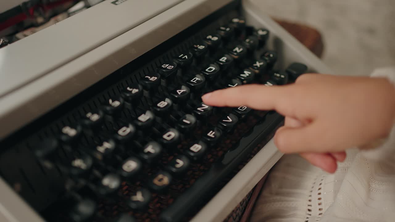 Kid Finger pressing a key on a vintage typewriter, evoking nostalgic holiday vibes