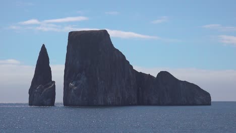 establishing shot of a rock formation in the galapagos islands ecuador from a boat