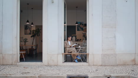 chica de moda sentada en un café sola sosteniendo un cuaderno. mujer de negocios tomando notas